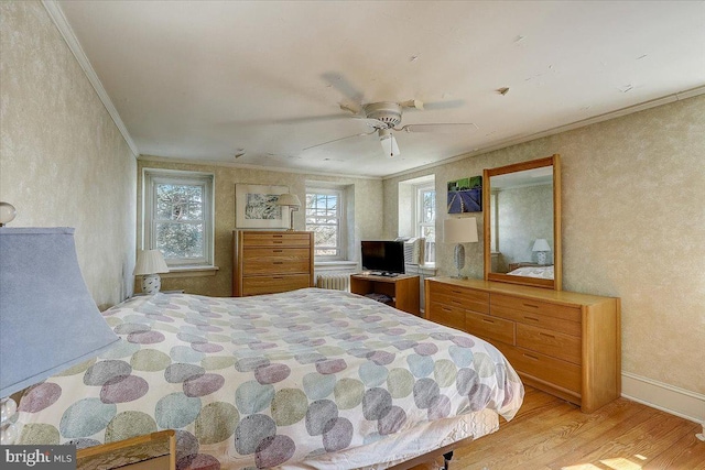 bedroom featuring baseboards, wood finished floors, a ceiling fan, and crown molding