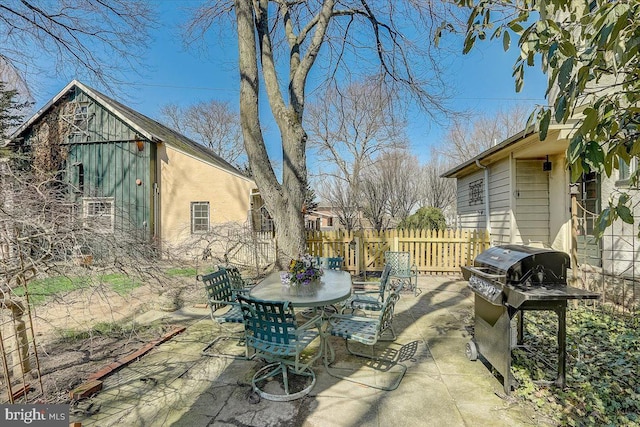 view of patio with outdoor dining area, fence, and area for grilling