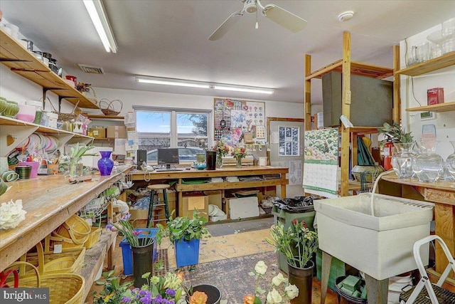 miscellaneous room featuring visible vents, unfinished concrete flooring, a sink, and a workshop area