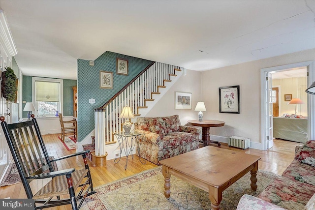 living room with wood-type flooring, stairs, and baseboards