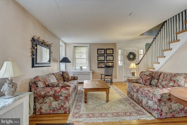 living area featuring stairway and wood finished floors