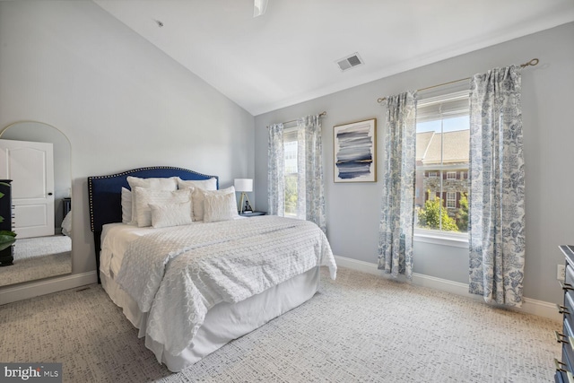 bedroom featuring high vaulted ceiling, baseboards, visible vents, and light colored carpet