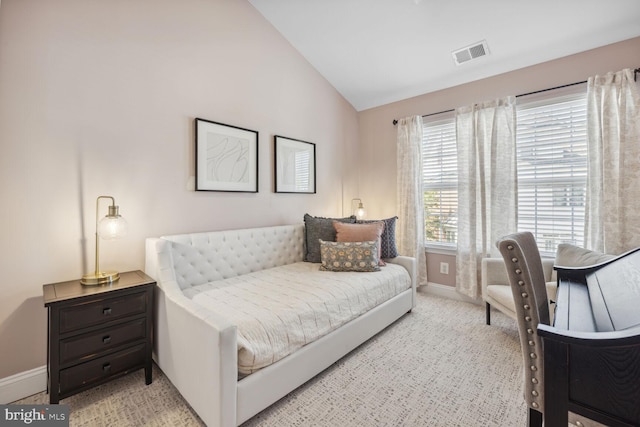 carpeted bedroom featuring baseboards, visible vents, and vaulted ceiling