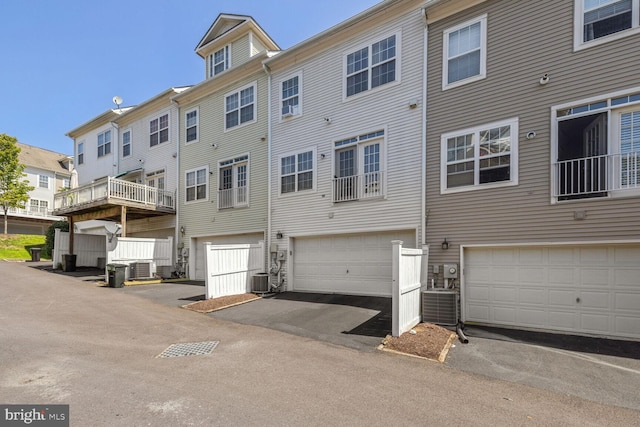 back of house featuring a garage and central AC