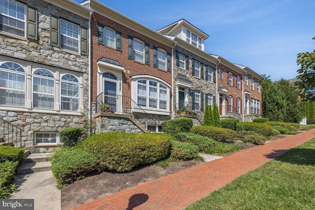 townhome / multi-family property featuring stone siding and brick siding