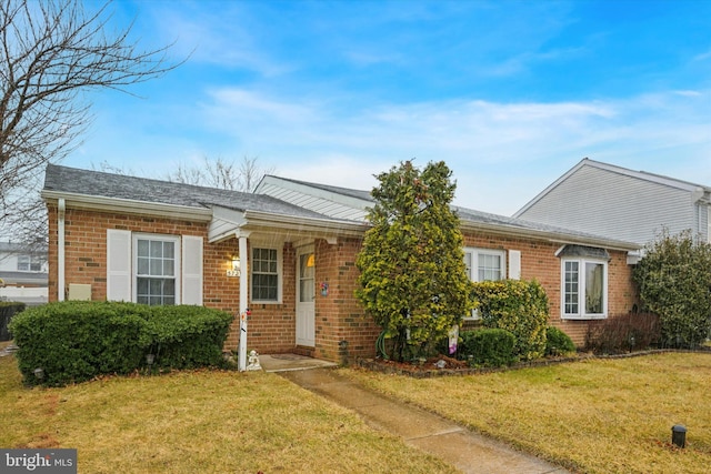 single story home featuring brick siding and a front yard