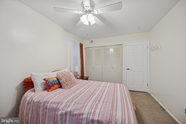 bedroom with baseboards, visible vents, a ceiling fan, carpet floors, and a closet