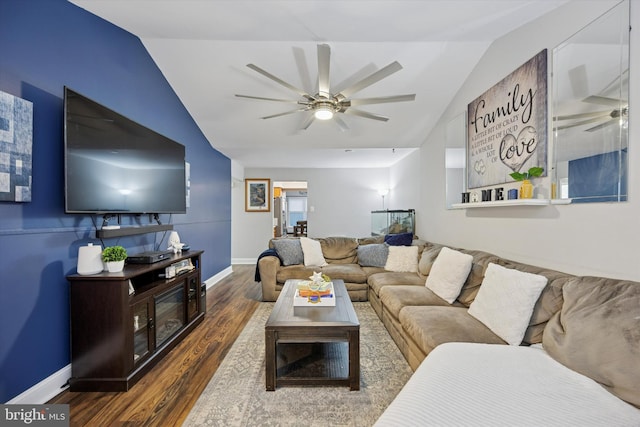 living area featuring baseboards, a ceiling fan, vaulted ceiling, and wood finished floors