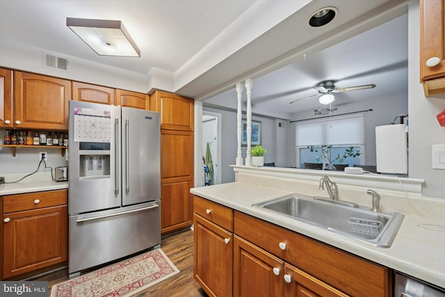 kitchen with brown cabinetry, a sink, and stainless steel fridge with ice dispenser