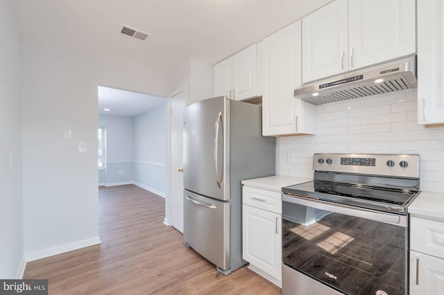 kitchen with under cabinet range hood, visible vents, appliances with stainless steel finishes, and white cabinets