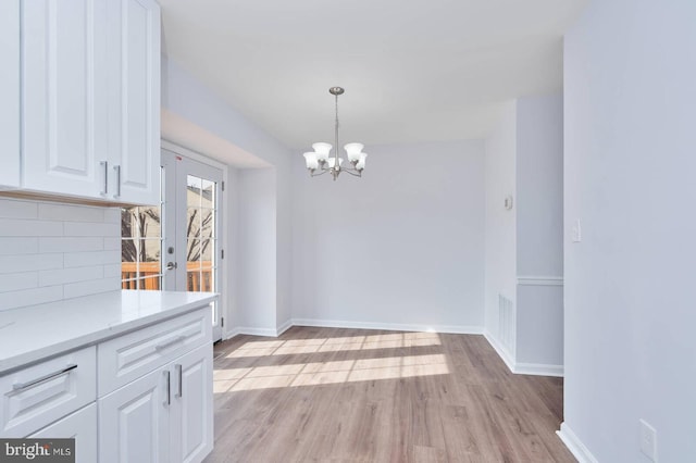 dining area with visible vents, light wood-style flooring, french doors, and baseboards