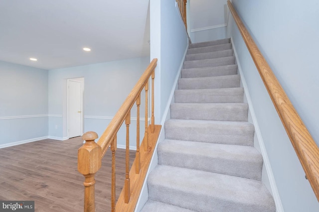 staircase featuring recessed lighting, baseboards, and wood finished floors