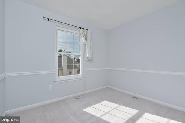 carpeted spare room with baseboards and visible vents