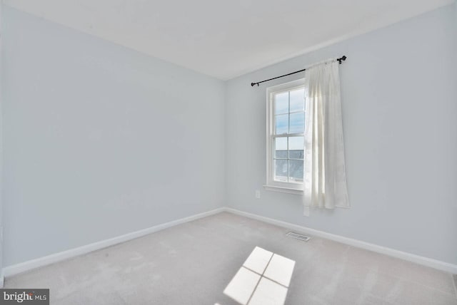 spare room featuring visible vents, baseboards, and carpet flooring