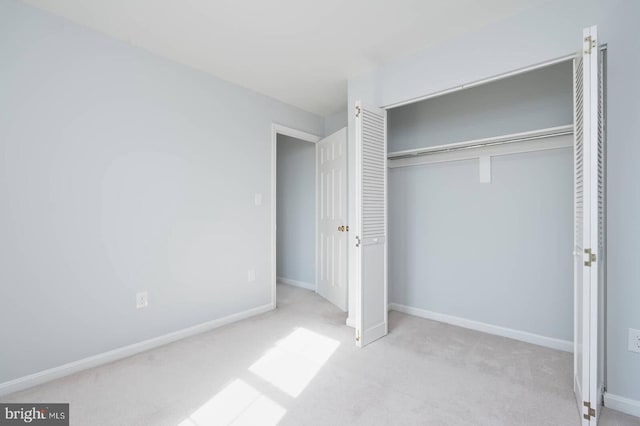 unfurnished bedroom with a closet, baseboards, and carpet