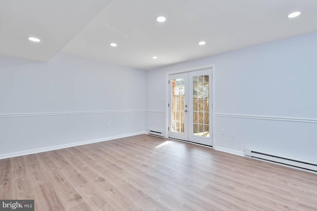 spare room with a baseboard radiator, recessed lighting, french doors, and wood finished floors