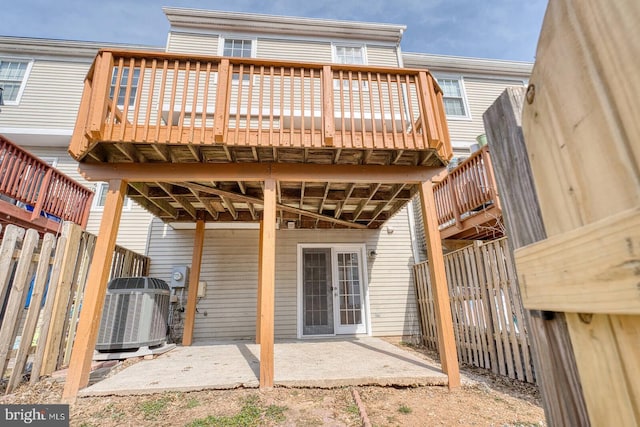 rear view of house with central AC unit, a patio area, fence, and french doors