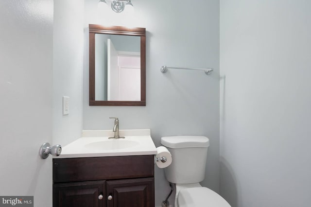 half bathroom featuring toilet and vanity