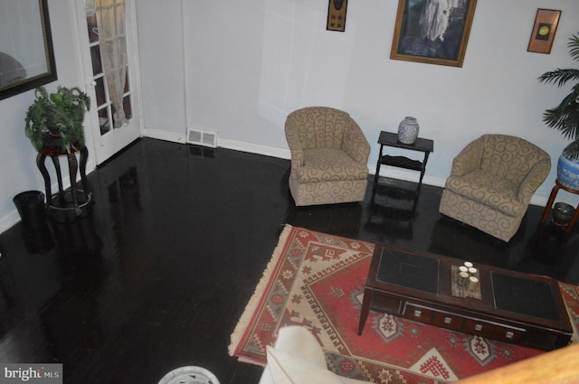 living area with baseboards and visible vents