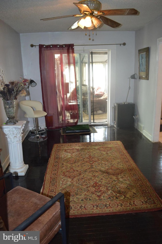 dining room with a textured ceiling, ceiling fan, wood finished floors, and baseboards