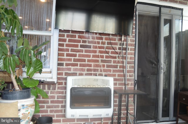 exterior details featuring brick siding and heating unit