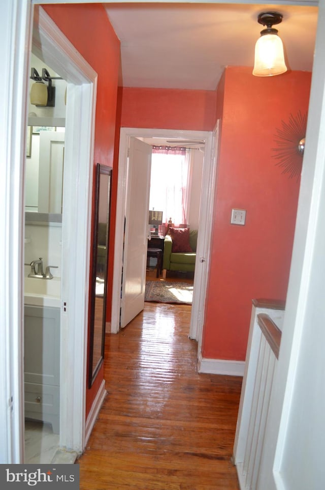 hallway with wood finished floors and baseboards