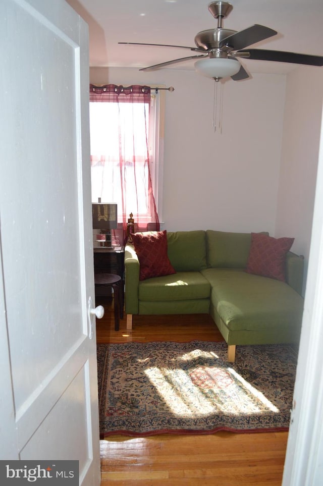 living room with ceiling fan and wood finished floors