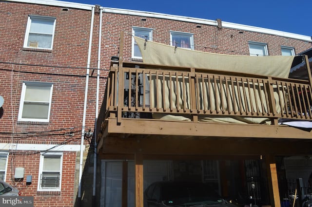 back of property with a garage and brick siding