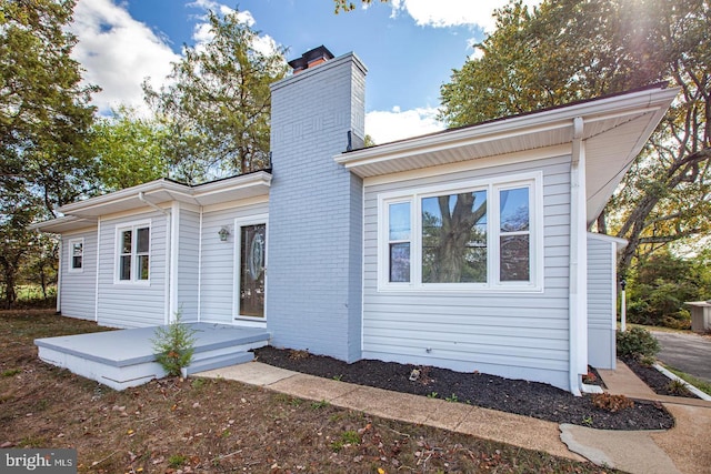 view of front of property featuring brick siding and a chimney