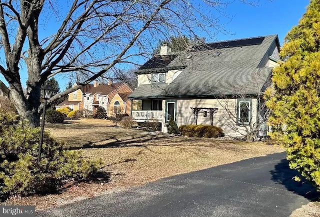 view of front of property featuring covered porch and a chimney