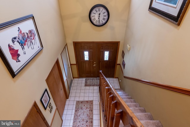 entrance foyer with stairway, a high ceiling, and light tile patterned floors