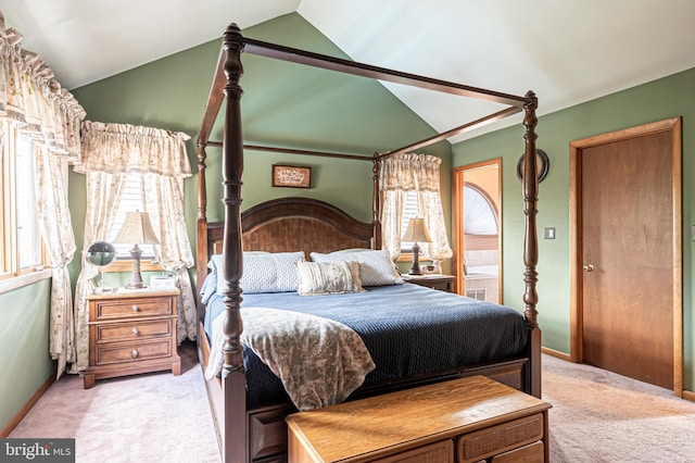 carpeted bedroom featuring lofted ceiling, connected bathroom, and baseboards