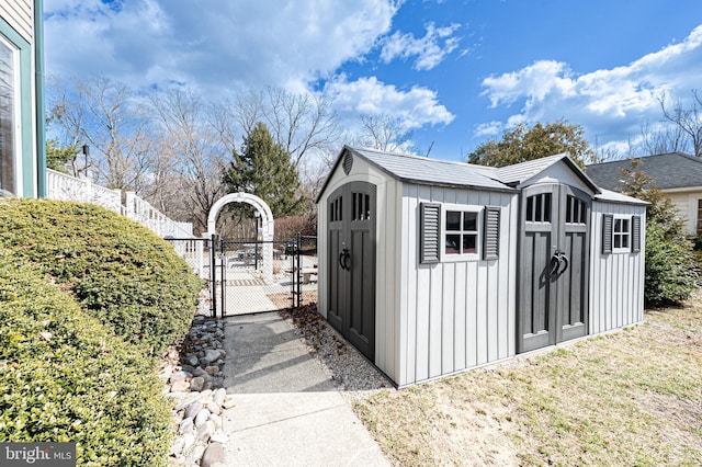 view of shed featuring a gate and fence