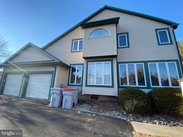 view of front facade with aphalt driveway and an attached garage