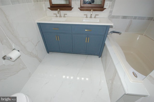 full bathroom with marble finish floor, a sink, toilet, and double vanity