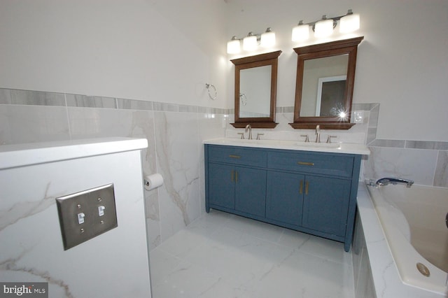 bathroom featuring a garden tub, a sink, tile walls, marble finish floor, and double vanity