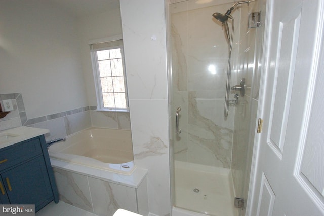 full bathroom with a shower stall, vanity, and a bath