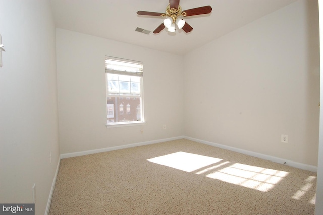 spare room with baseboards, visible vents, and a ceiling fan