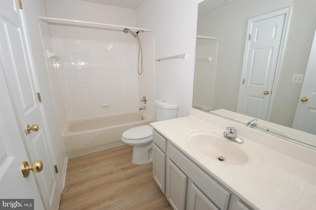 bathroom with toilet, shower / tub combination, wood finished floors, and vanity