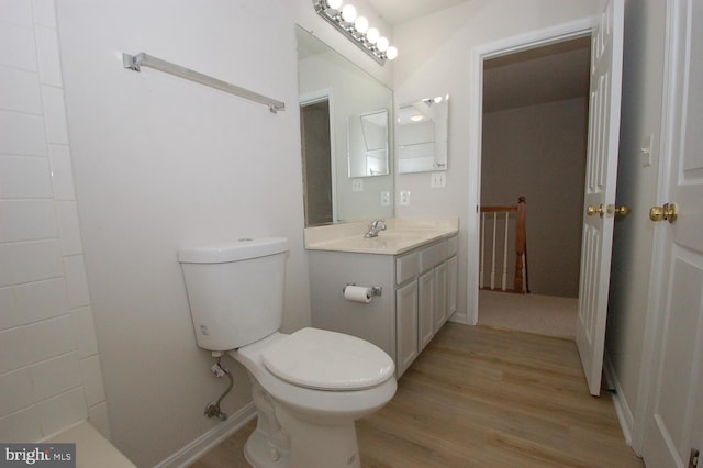 bathroom featuring toilet, wood finished floors, and vanity