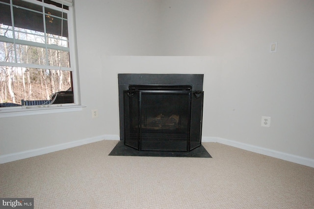 interior details with a fireplace with flush hearth, carpet flooring, and baseboards