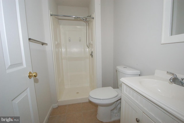 bathroom featuring toilet, a shower stall, vanity, and tile patterned floors