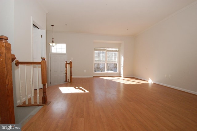 interior space featuring baseboards, wood finished floors, and crown molding