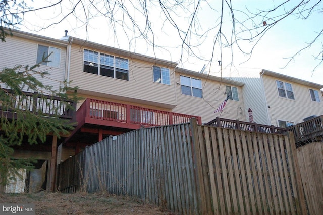 back of house featuring a deck and fence