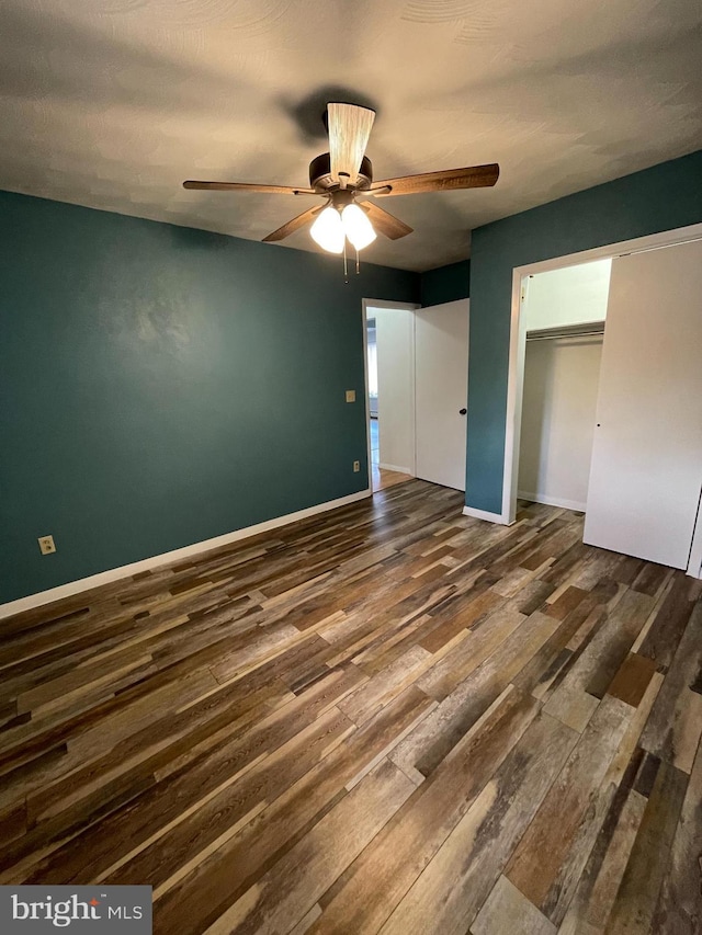 unfurnished bedroom with ceiling fan, dark wood finished floors, and baseboards