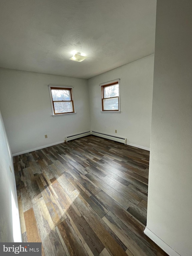 unfurnished room featuring baseboards, plenty of natural light, and hardwood / wood-style floors