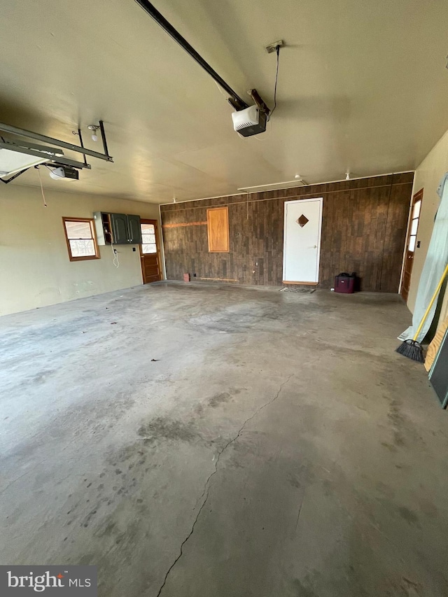 garage featuring a garage door opener and wood walls