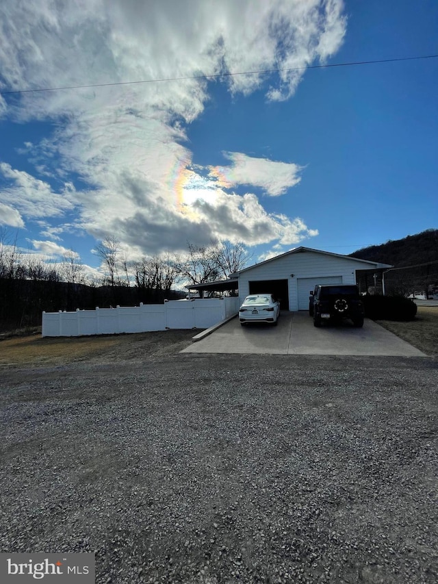 view of yard featuring a detached garage, fence, and an outdoor structure