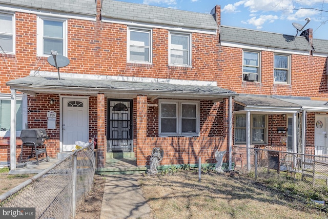 view of property featuring brick siding and fence