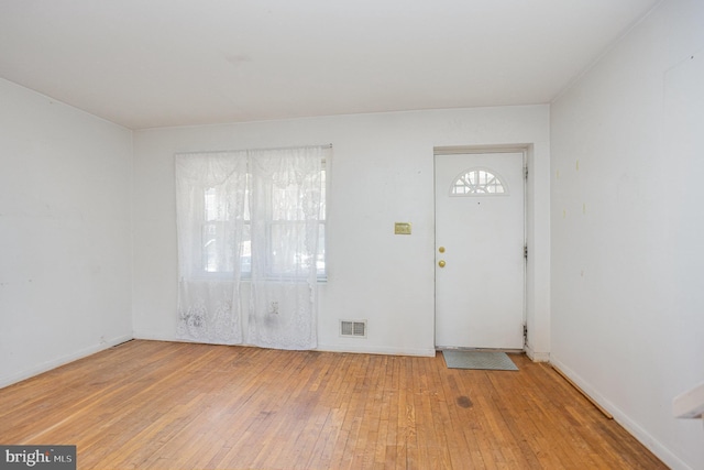 entrance foyer with hardwood / wood-style floors, visible vents, and baseboards